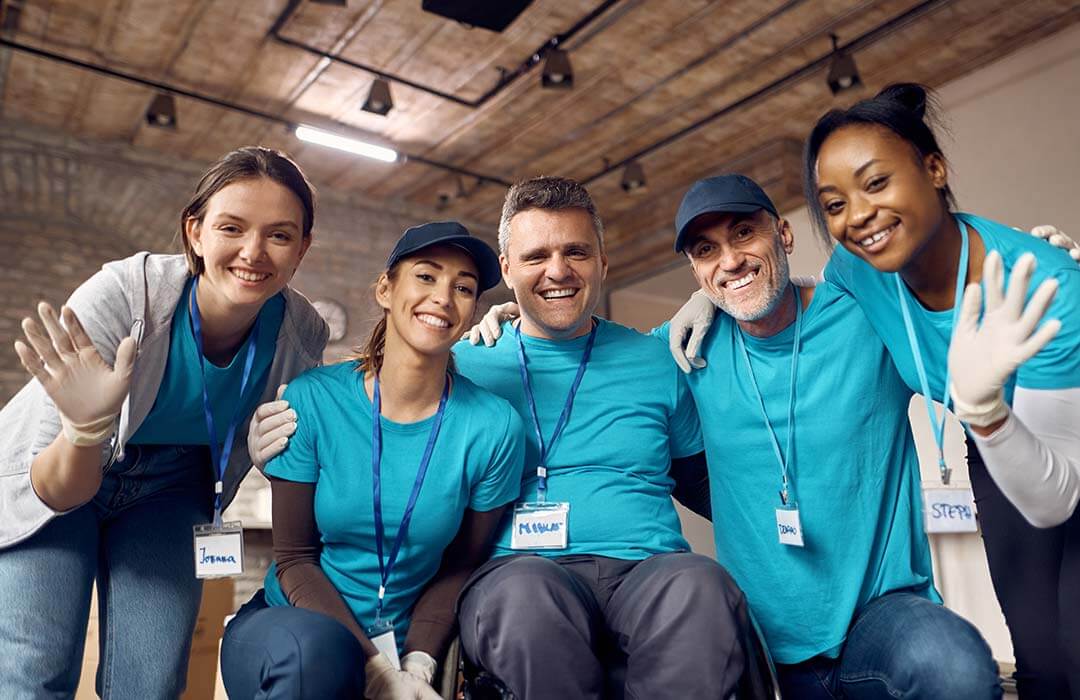 Team of disability support volunteers smiling together.