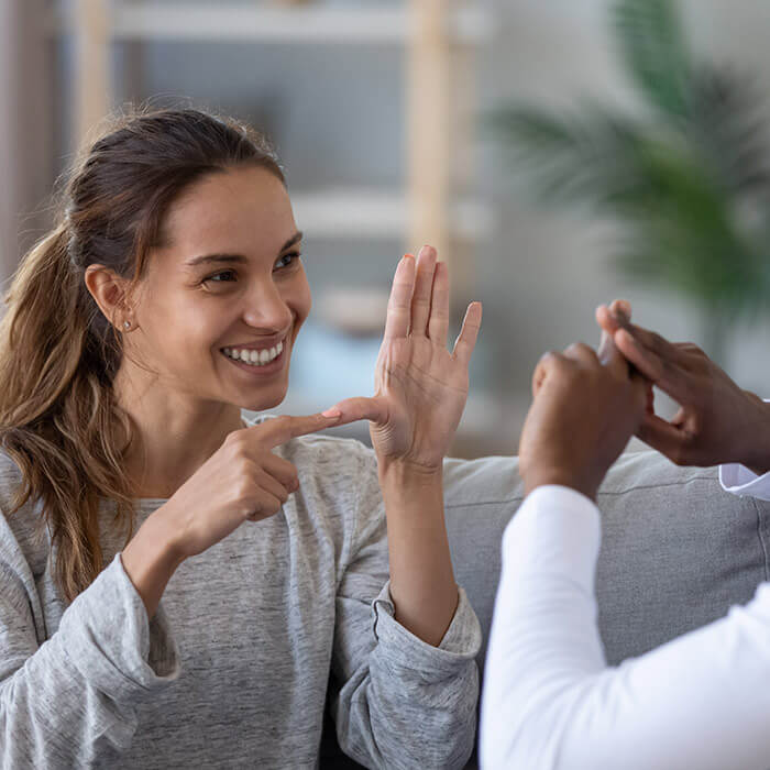 Woman helping hearing-impaired man with interpretation.