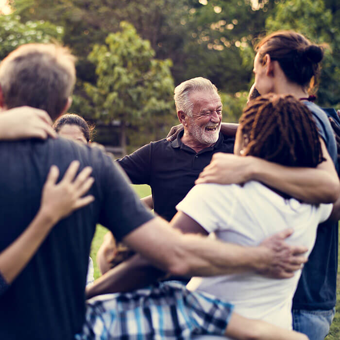 Man smiling with community group with NDIS core support funding.