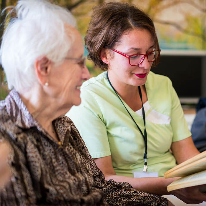 Core Support NDIS worker reading to a particpant.