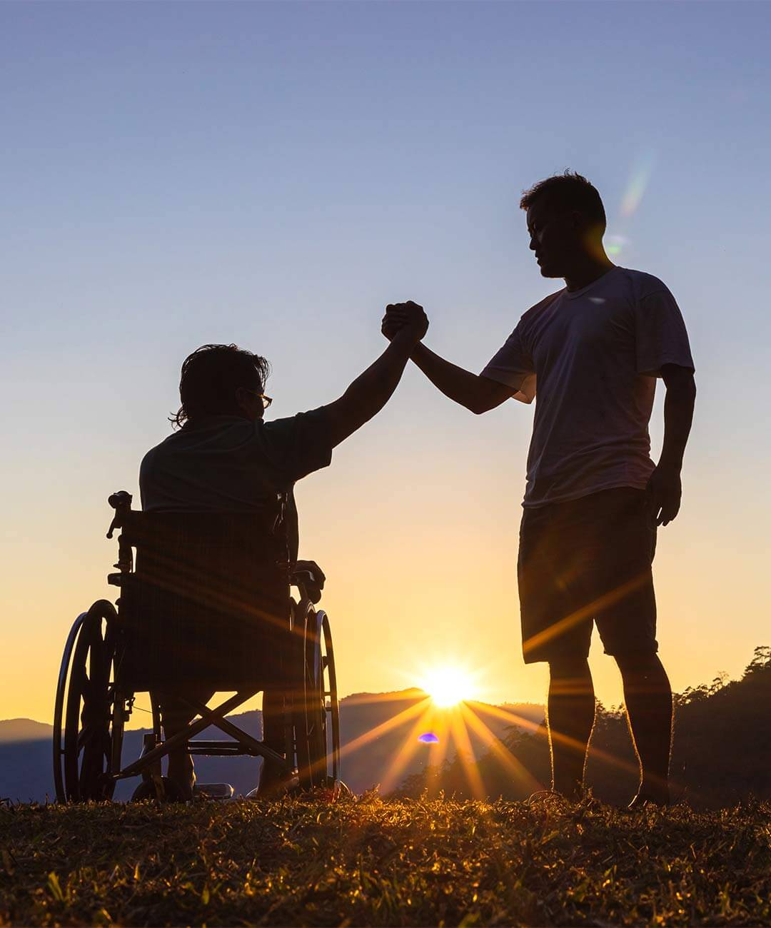 Team member at your Own Way shaking hands with NDIS participant in wheelchair.